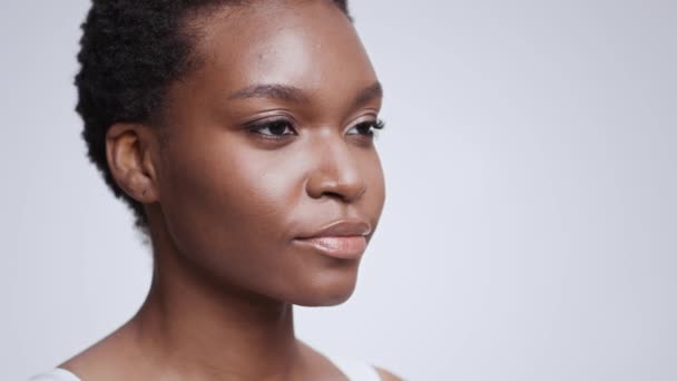 Kecantikan pemuda. Potret profil semi dari wanita Amerika afrika cantik dengan kulit halus melihat ke samping, ruang kosong — Stok Video