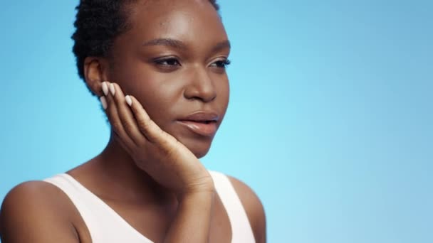 Problemas de salud dental. Joven mujer afroamericana molesta que sufre de dolor de muelas agudo, tocando su mandíbula inflamada — Vídeo de stock