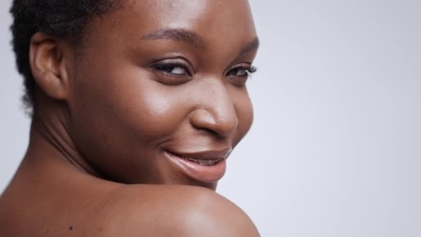 Tandläkarestetik. Ung vacker afrikansk amerikansk dam med tandställning ler mot kameran, tomt utrymme, slow motion — Stockvideo