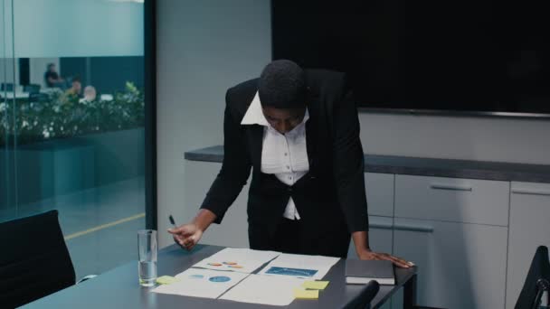 Schwarze Geschäftsfrau in formeller Kleidung überprüft Finanzberichte im Amt — Stockvideo