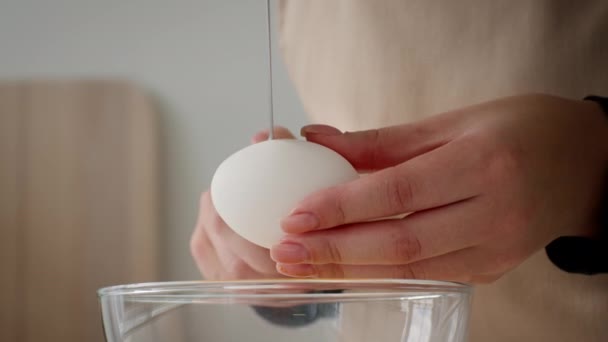 Oigenkännlig kvinna knäcka ägg med kniv matlagning i köket, närbild — Stockvideo
