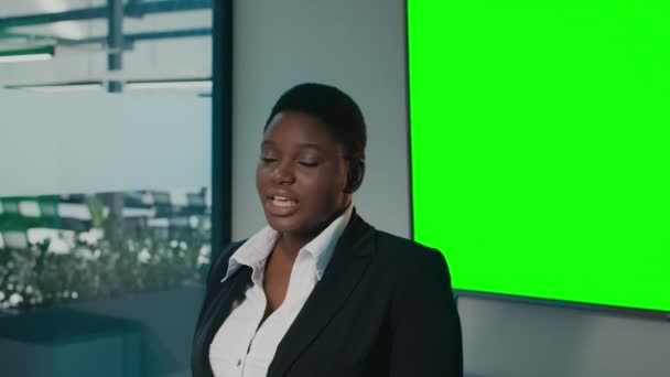 自信的黑人女商人在接近绿色的办公室关键屏幕上发表演讲 — 图库视频影像