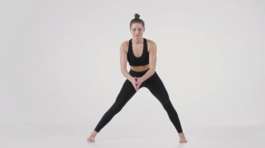 Yoga pozlarıyla esnekliğin ve duruşun gelişimi. Genç aktif kadın vücudunu esnetiyor.