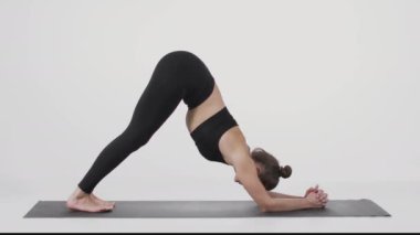 Yoga eğitimi. Bronz tenli genç bayanın spor minderinde Asana 'yı gösterirken, vücut esnerken yan görüntüsü.