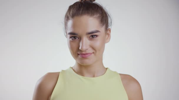 Juventud y belleza. Primer plano retrato de joven atractiva mujer caucásica sonriendo a la cámara, fondo de estudio blanco — Vídeos de Stock