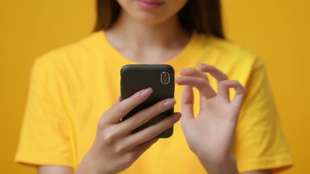Close-Up Of Smartphone Podczas azjatyckich kobiet przewijanie wiadomości, żółte tło — Wideo stockowe