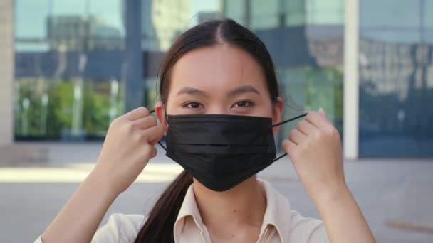 Aziatisch ondernemer dame opstijgen beschermende gezicht masker staande buiten — Stockvideo