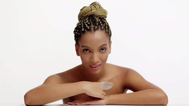 Schwarze Millennial Frau streichelt Dekolleté mit Feder über weißem Hintergrund — Stockvideo