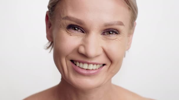Cuidado de la piel antienvejecimiento. Hermosa mujer madura con arrugas cerca de los ojos mirando la cámara — Vídeo de stock