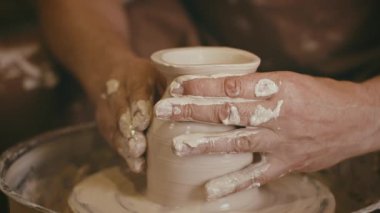Erkek Potter Şekillendirme Kupası. Kapalı alanda Pottery Wheel üzerinde çalışıyor.