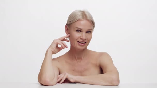 Öreg Szépség. Vonzó érett nő csupasz váll pózol át fehér háttér — Stock videók