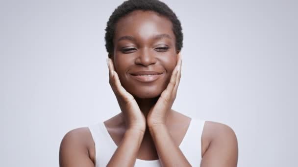 Auto amor y concepto de confianza. Joven mujer afroamericana hermosa con frenos dentales tocando su cara perfecta — Vídeo de stock