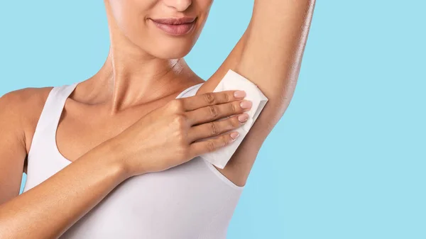 Closeup of unrecognizable young woman wiping armpit — Stock Photo, Image