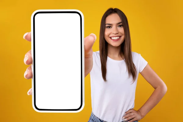 Mujer mostrando blanco pantalla vacía del teléfono inteligente cerca de la cámara — Foto de Stock