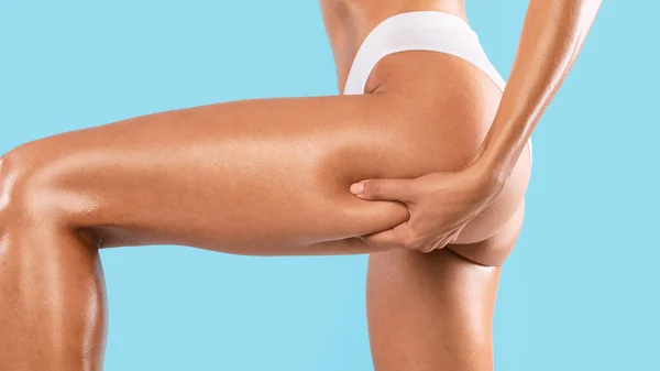 Irriconoscibile giovane donna pizzicando le natiche, esaminando la cellulite — Foto Stock