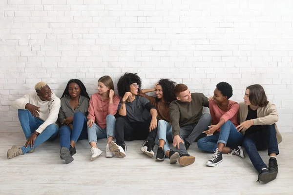 Milenials multirraciales que se relajan juntos, sentados en el suelo — Foto de Stock