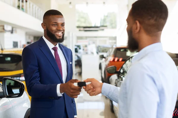 Venta de coches o alquiler. Gerente negro que da llaves al cliente masculino, primer plano —  Fotos de Stock