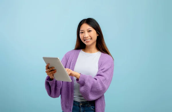 Çevrimiçi hayat. Uzak çalışma ya da mavi stüdyo geçmişi üzerine eğitim için tablet kullanan Asyalı genç bayan, kopya alanı — Stok fotoğraf