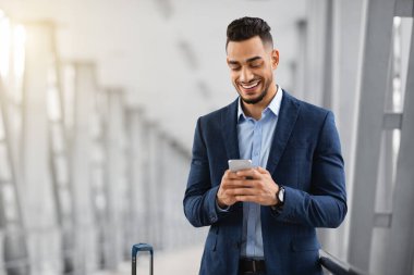 Mobil İletişim. Yakışıklı Orta Doğulu İş Adamı Havalimanında Akıllı Telefon Kullanıyor