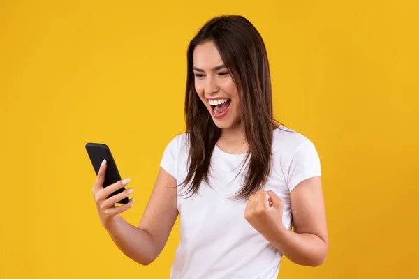 Happy excited lady using mobile phone at studio, saying yes — Stock Photo, Image