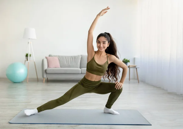 Deportiva mujer india estirando su cuerpo durante el entrenamiento en casa, espacio de copia — Foto de Stock