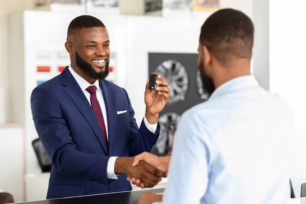 Black Salesman And Male Customer Shaking Hands After Deal In Dealership Center — Stock Photo, Image