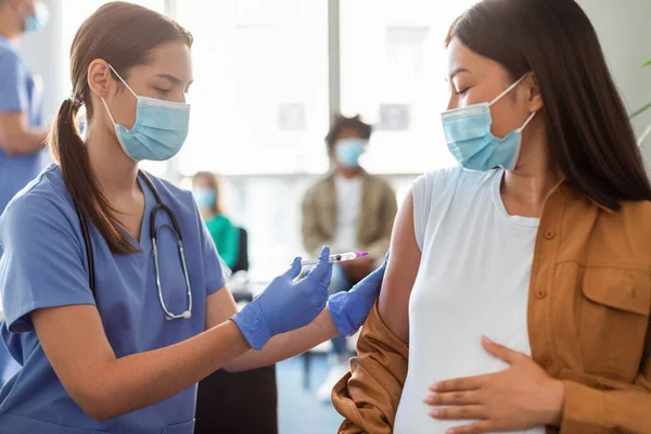 Těhotná asijská dáma dostává vakcínu Jab v náručí — Stock fotografie