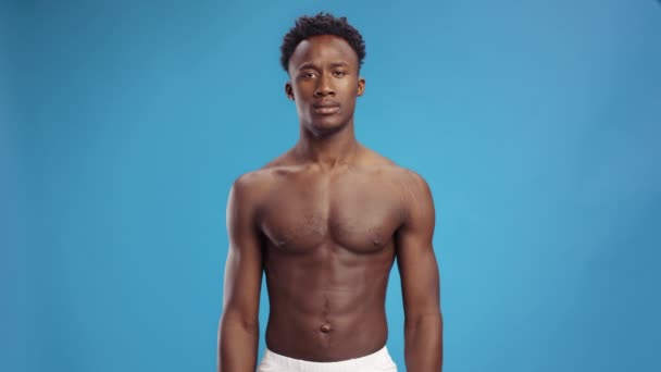 Základní instinkty. Agresivní Afroameričan bez trička protahuje svaly a šklebí se, předvádí svou sílu — Stock video