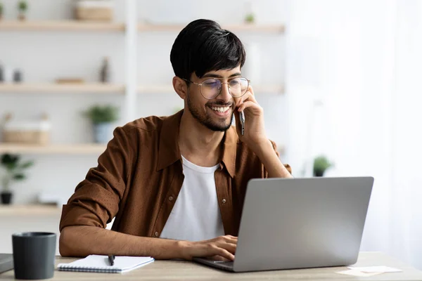 Glada indian kille affärsman med bärbar dator har telefon konversation — Stockfoto