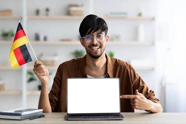 Lächelnder arabischer Student zeigt Deutschland-Fahne und Laptop — Stockfoto