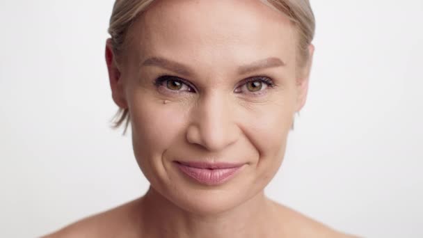 Крупный план красивой женщины средних лет с натуральным макияжем, смотрящей в камеру — стоковое видео