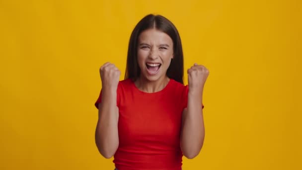 Жінка Shouting І Shaking Кулаки В Радість Над Жовтим Тлом — стокове відео