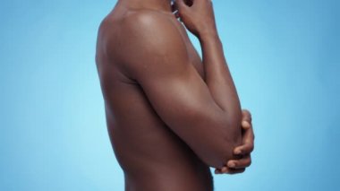 Tanımlanamayan siyah gömleksiz bir adamın profil portresi ağrıyan dirseğine masaj yapıyor, kemik ağrısından muzdarip.