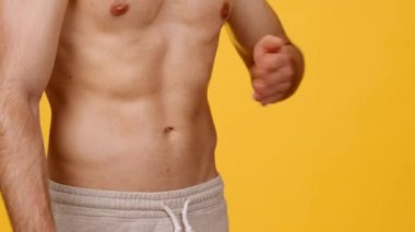 Spor eğitimi sonucu. Göbeğine tokat atan, kaslı karın kaslarını gösteren, serbest alan gösteren tanınmamış, üstsüz adam.