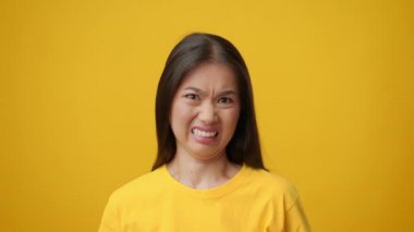 Hoşnutsuz Koreli Genç Bayan Sarı Arkaplan 'a Çırpınıyor