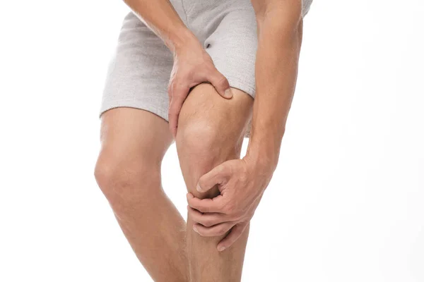 Cultivado millennial europeo atleta masculino que sufre de dolor de rodilla, presiona su mano para dolor de mancha — Foto de Stock