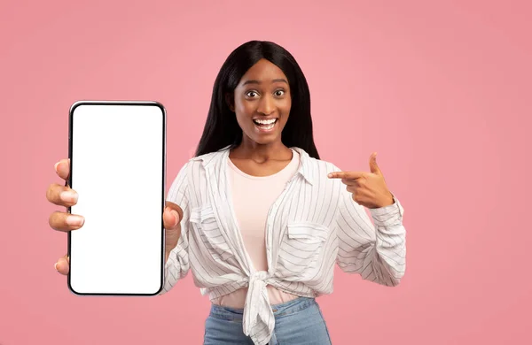 Amazed african american woman showing big smartphone with blank screen — Stock Photo, Image