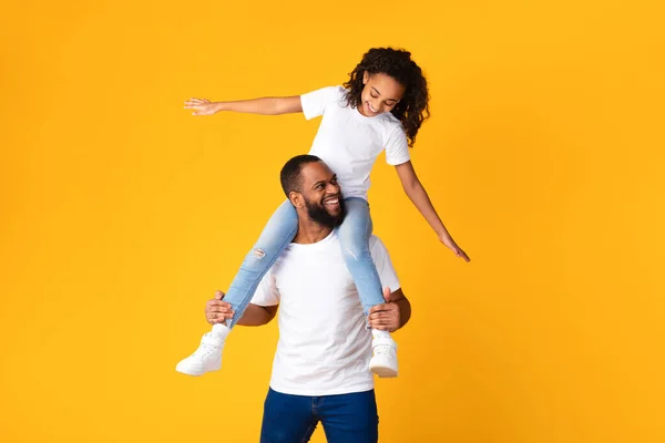 Веселий афроамериканський чоловік скаче збуджена дочка на шиї — стокове фото