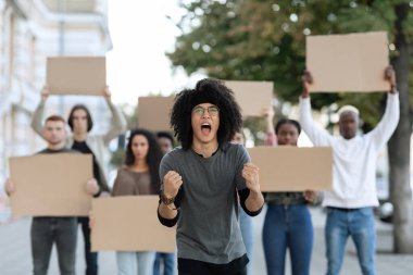 Sokaktaki bir grup göstericiyi yöneten duygusal bir adam.