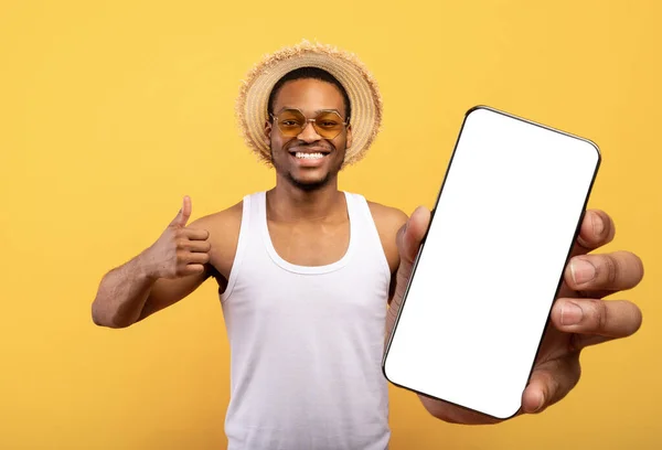 Alegre turista negro mostrando teléfono celular con pantalla en blanco — Foto de Stock