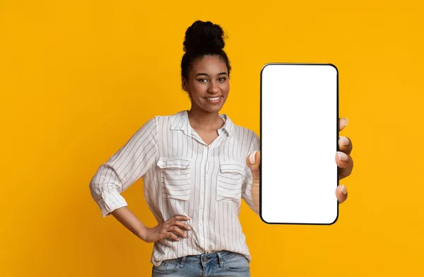 Elegante mujer afroamericana sosteniendo un gran teléfono inteligente con pantalla vacía — Foto de Stock