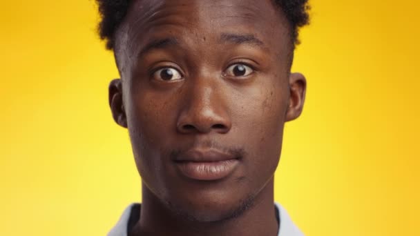 Schokkende reactie. Jonge verbijsterd Afrikaans-Amerikaanse man opent zijn ogen wijd in verbazing, kijkend naar camera — Stockvideo