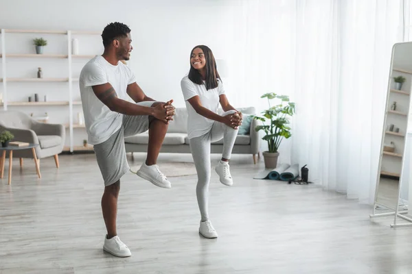 Giovane coppia nera che fa esercizio al ginocchio alto — Foto Stock