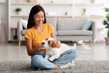 Neşeli Japon bayan köpeğine evde ikramda bulunuyor.