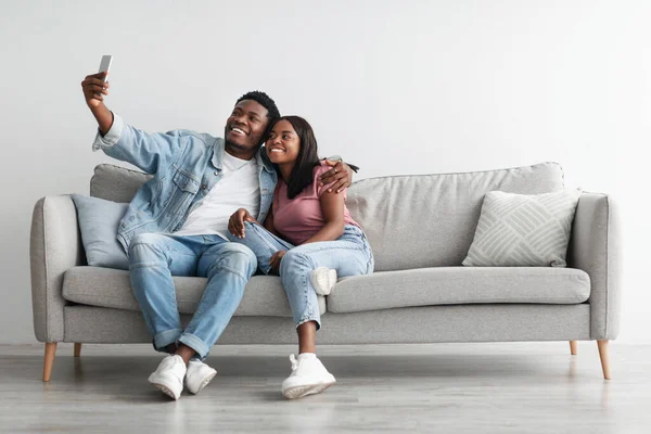 Retrato de casal afro-americano tirando selfie juntos em casa — Fotografia de Stock