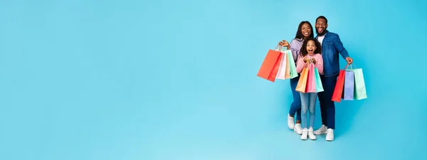 Afroamericanos alegres sosteniendo bolsas de compras mirando a la cámara —  Fotos de Stock