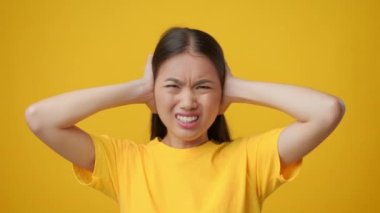 Asya 'lı Kadın Kulakları Kaplıyor Elleri Titreyen Kafa, Sarı Arkaplan