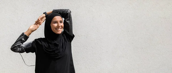Sederhana Sportswear. Happy Islamic Lady In Hijab Warming Up Before Training Outdoors — Stok Foto