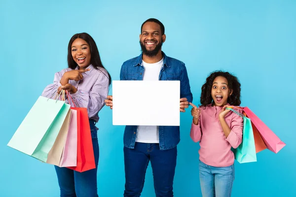 Gente negra alegre sosteniendo bolsas de compras apuntando a pancarta de papel —  Fotos de Stock