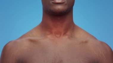 Tanımlanamayan Afro-Amerikan adam boğaz ağrısı çekiyor, siyah adamın boynunda kırmızı titreşim var, ağır çekim.